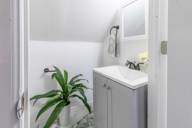 bathroom with lofted ceiling and vanity