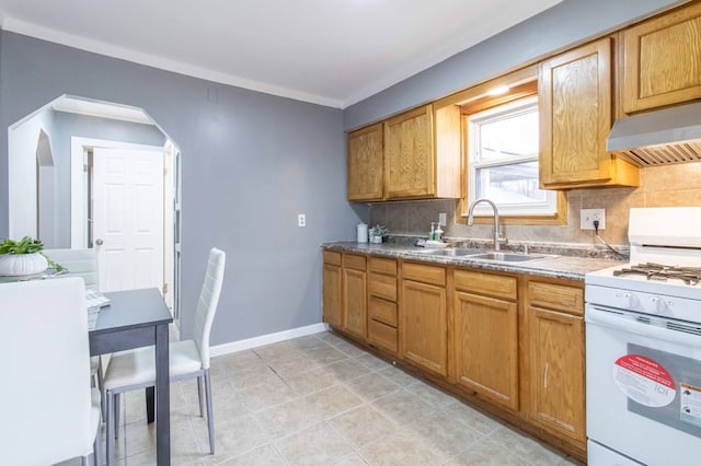 kitchen featuring arched walkways, decorative backsplash, white gas range, under cabinet range hood, and a sink