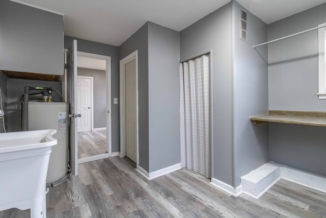 bathroom with visible vents, baseboards, wood finished floors, and electric water heater