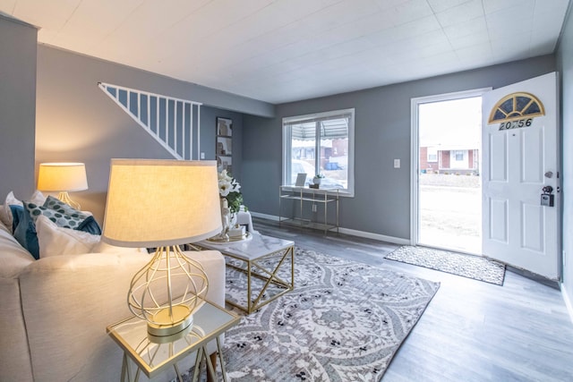 living room with stairway, baseboards, and wood finished floors