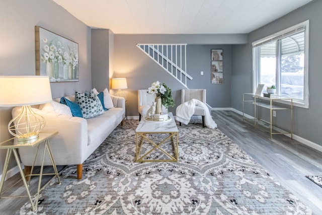 living room featuring stairs, wood finished floors, and baseboards