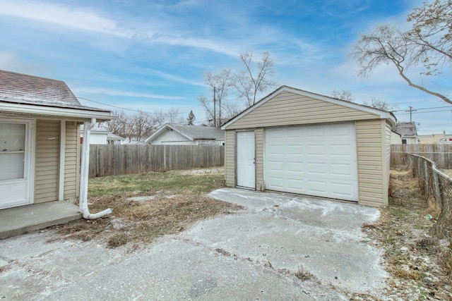 detached garage with driveway and fence