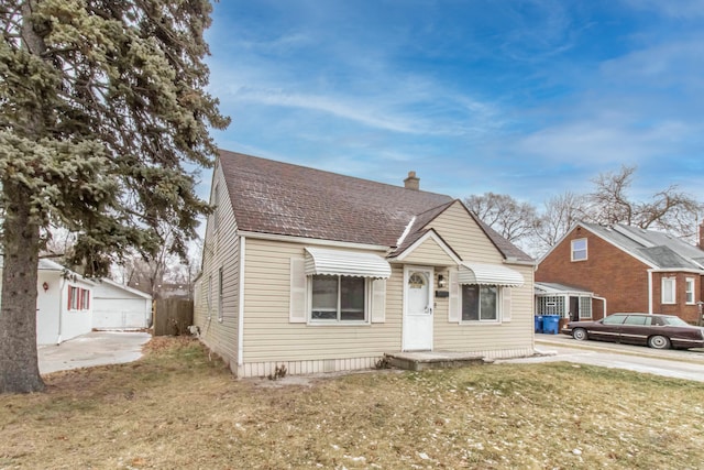 bungalow with a shingled roof, a chimney, and a front yard