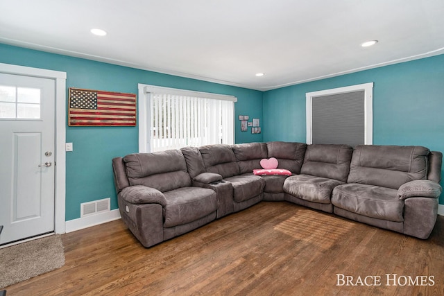 living room with recessed lighting, visible vents, baseboards, and wood finished floors