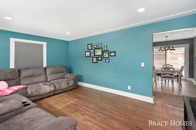 living area featuring baseboards, wood finished floors, and recessed lighting