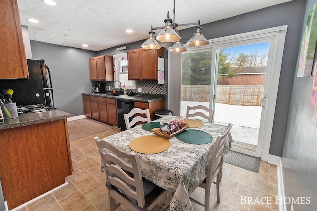 kitchen with dark countertops, black appliances, tasteful backsplash, and brown cabinetry