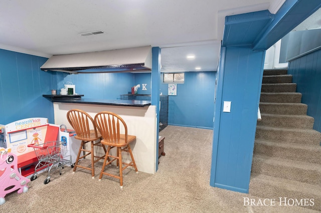 bar with stairs, a bar, carpet, and visible vents