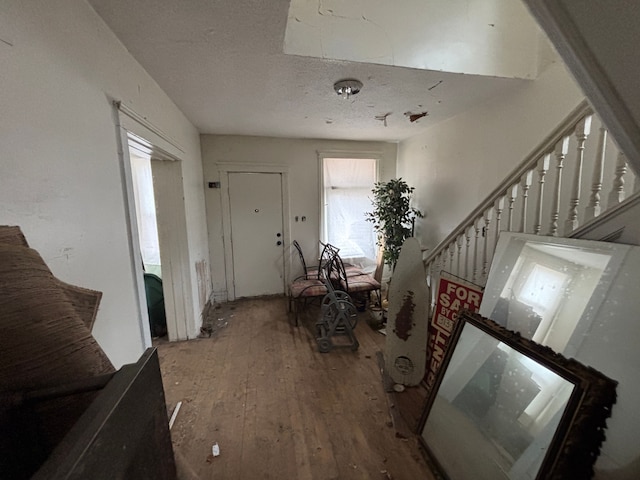 entryway with a textured ceiling, stairway, and hardwood / wood-style flooring