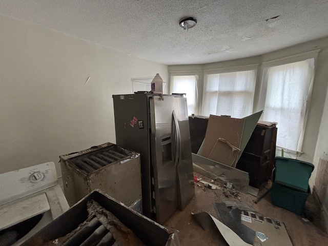 miscellaneous room with a textured ceiling and washer / dryer