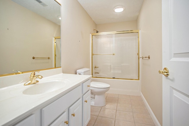 full bath featuring toilet, vanity, a textured ceiling, and tile patterned floors