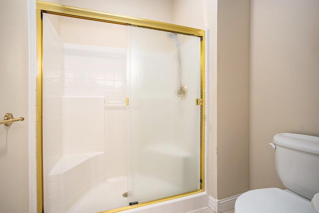 full bathroom featuring toilet and a shower stall