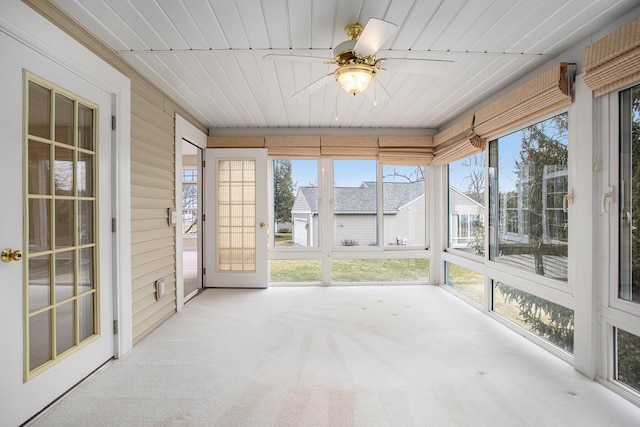 unfurnished sunroom featuring wood ceiling and ceiling fan