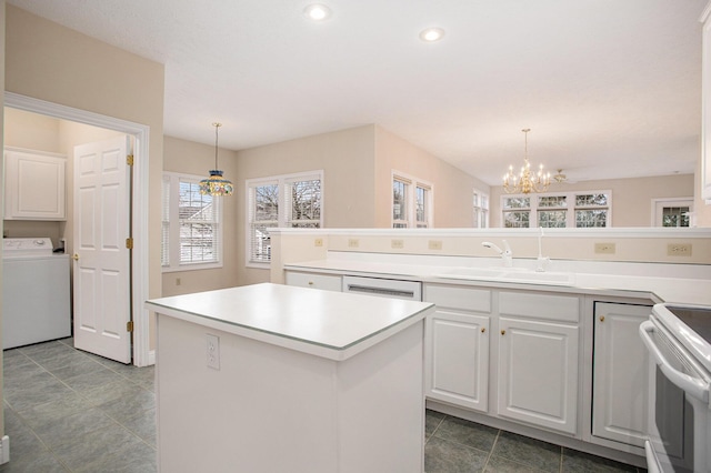 kitchen featuring white appliances, a sink, white cabinets, washer / dryer, and an inviting chandelier