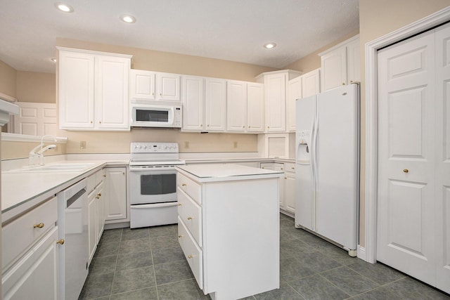 kitchen featuring a kitchen island, white appliances, white cabinetry, and a sink