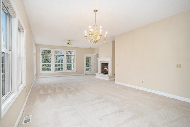 unfurnished living room featuring light carpet, a glass covered fireplace, visible vents, and baseboards