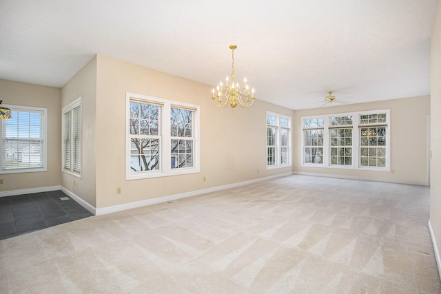 unfurnished room featuring baseboards, carpet floors, ceiling fan with notable chandelier, and a healthy amount of sunlight