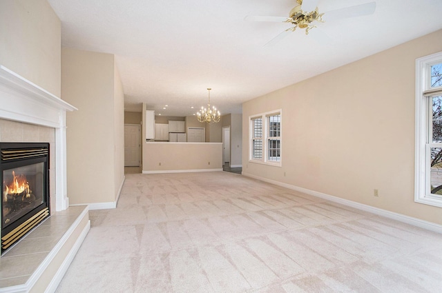 unfurnished living room with baseboards, light carpet, plenty of natural light, and a tiled fireplace