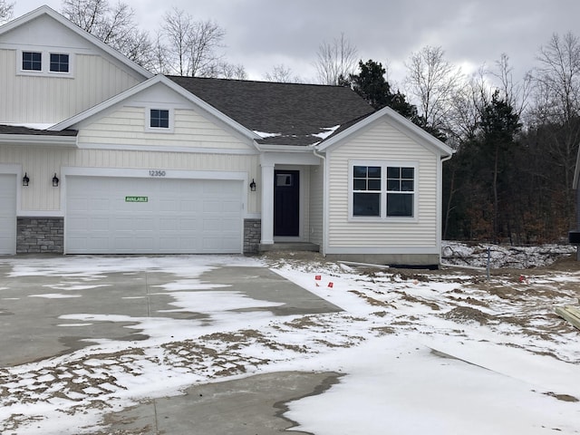 view of front facade with stone siding, roof with shingles, driveway, and an attached garage