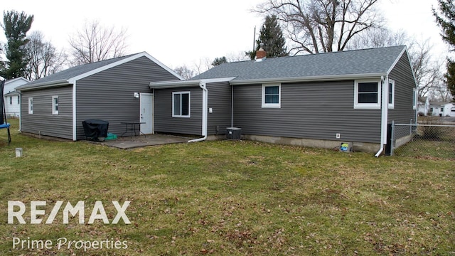 rear view of property featuring fence, a patio area, a lawn, a trampoline, and a chimney