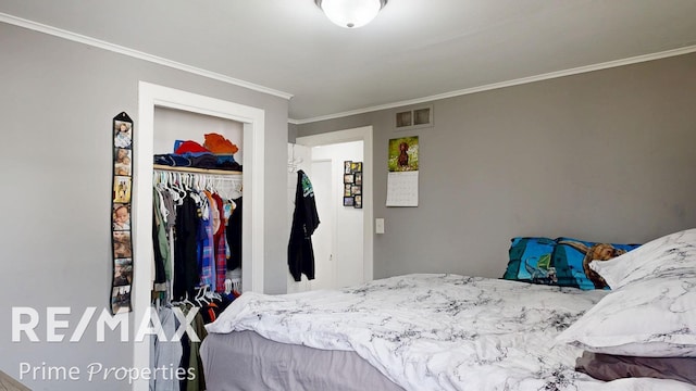 bedroom with a closet, visible vents, and crown molding