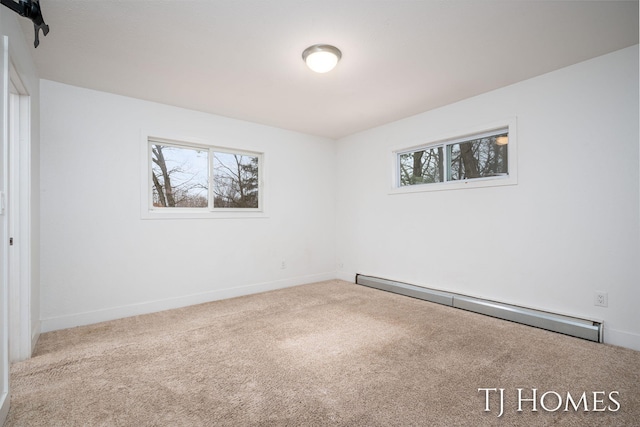 carpeted empty room with a baseboard heating unit and baseboards