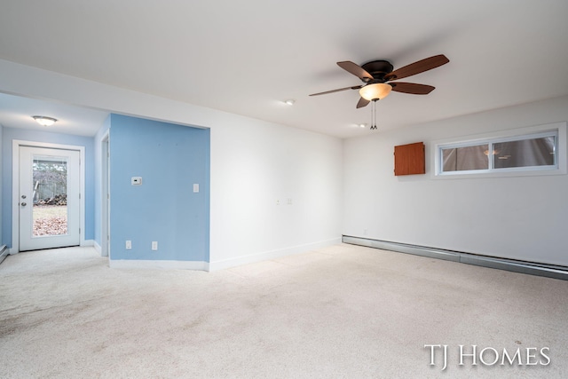 spare room with light carpet, a baseboard radiator, a ceiling fan, and baseboards