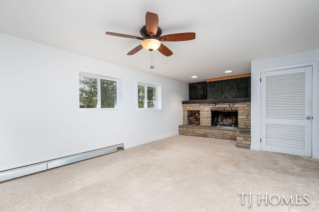 unfurnished living room with ceiling fan, a stone fireplace, recessed lighting, carpet floors, and baseboard heating