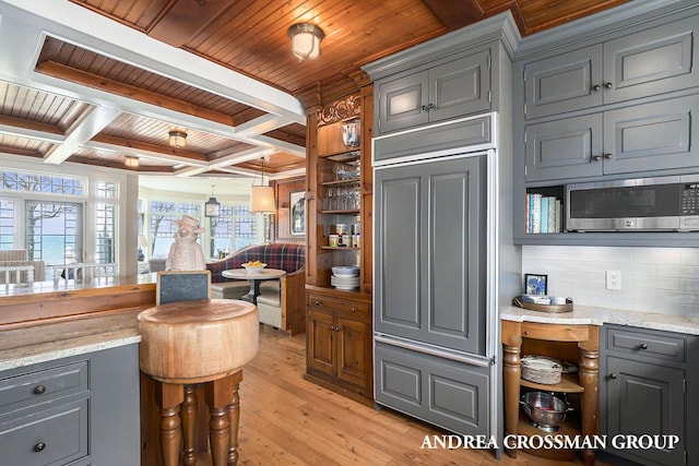 6059 Lakeshore Dr, West Olive, MI 49460 - kitchen with light wood-style floors, stainless steel microwave, paneled refrigerator, and gray cabinetry