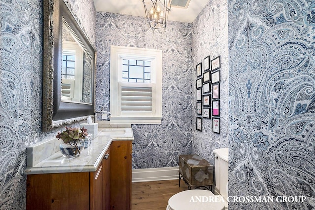 6059 Lakeshore Dr, West Olive, MI 49460 - bathroom with toilet, wood finished floors, vanity, baseboards, and wallpapered walls