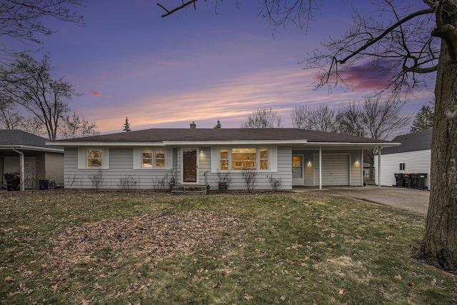 ranch-style home featuring a yard, driveway, and an attached garage