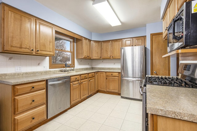 kitchen with stainless steel appliances, tasteful backsplash, a sink, and brown cabinets