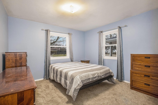 bedroom with baseboards and light colored carpet