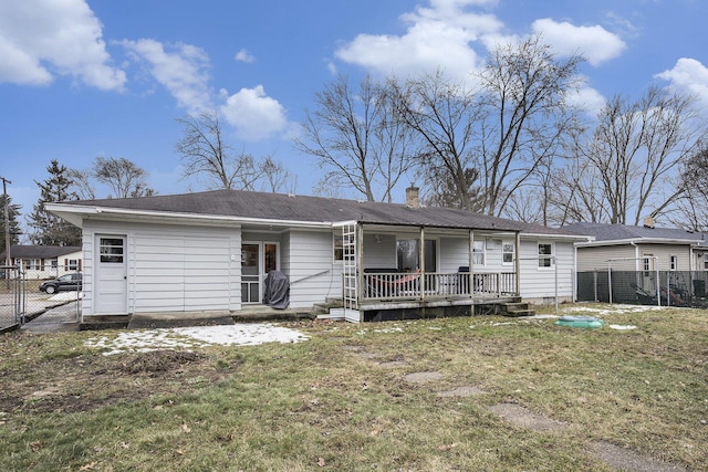 rear view of property with a yard, a gate, fence, and a chimney