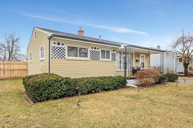 view of front facade featuring a chimney, a porch, board and batten siding, fence, and a front lawn