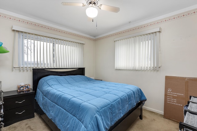 carpeted bedroom with ceiling fan and baseboards