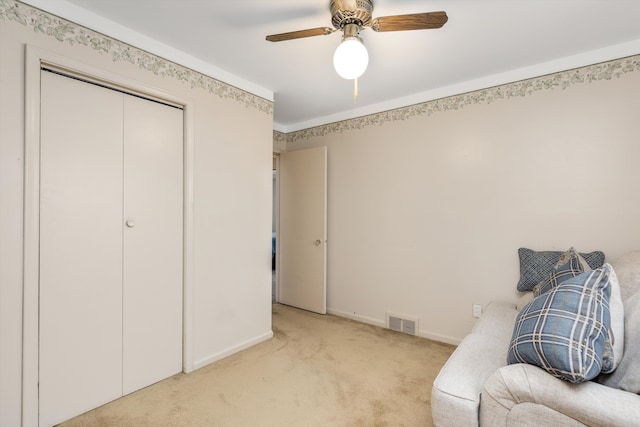 sitting room featuring baseboards, a ceiling fan, visible vents, and light colored carpet