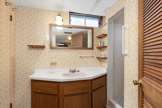 bathroom featuring a stall shower, vanity, and wallpapered walls