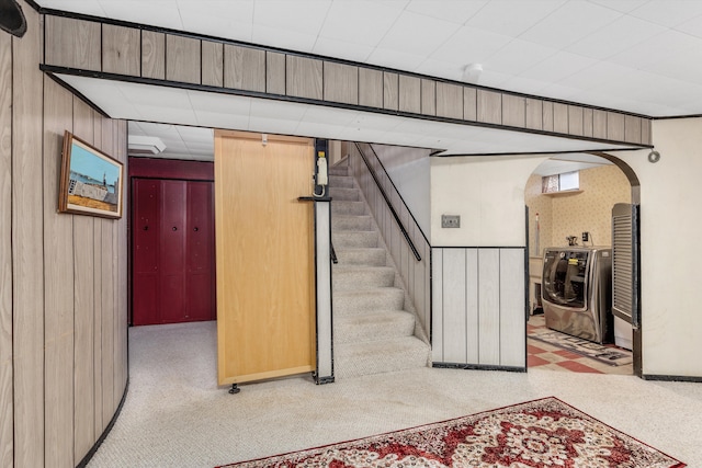 stairs featuring wooden walls and washer / clothes dryer