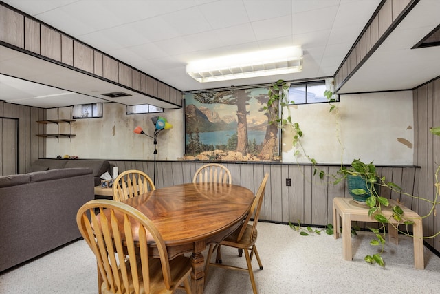 dining area with wood walls and visible vents