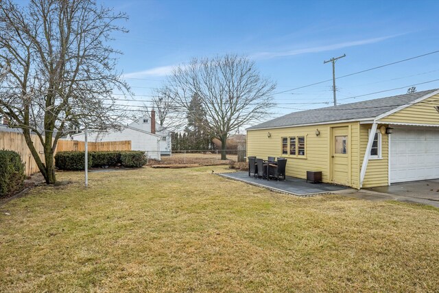 view of yard with an outbuilding, a detached garage, and fence