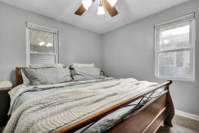 carpeted bedroom with a ceiling fan and baseboards