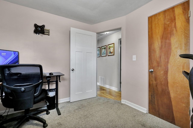 carpeted office space with visible vents and baseboards