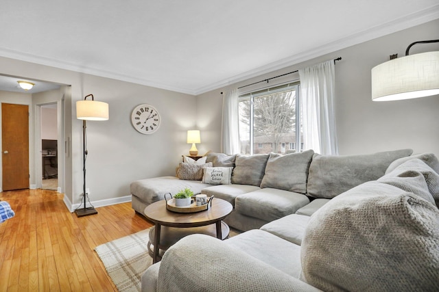 living area with light wood finished floors, baseboards, and crown molding