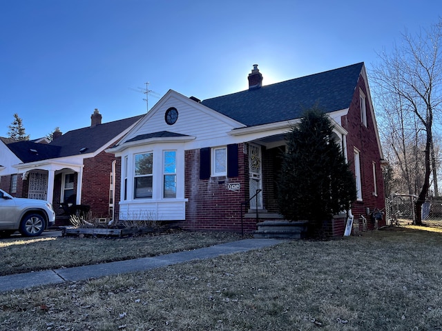 view of front of home featuring brick siding, a chimney, and roof with shingles