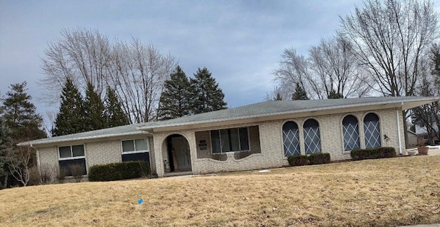 single story home with brick siding and a front yard