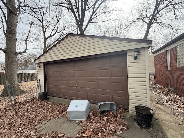 detached garage featuring fence