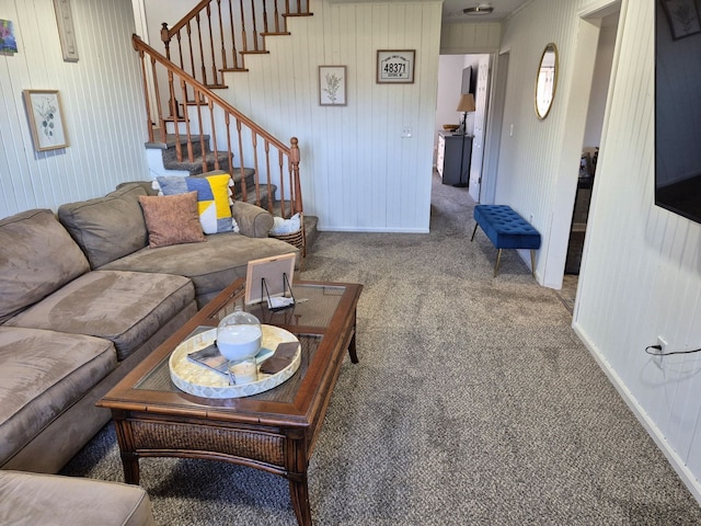 living area featuring carpet, stairs, and baseboards