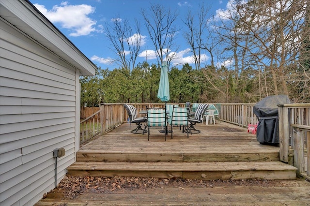 wooden deck featuring outdoor dining area and a grill