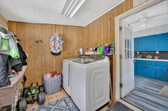 laundry area featuring a ceiling fan, washing machine and dryer, laundry area, and wood walls