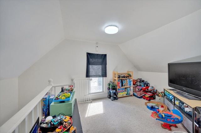 recreation room featuring carpet and vaulted ceiling